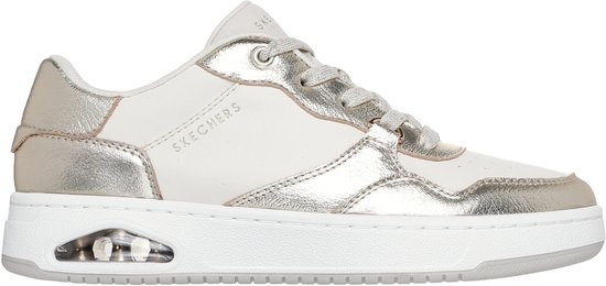 Zijaanzicht van een witte sneaker met champagnekleurige leren panelen, veters en een witte zool met luchtdemping.