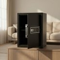 Zwarte kluis met de deur open, in een woonkamer met bank op de achtergrond.