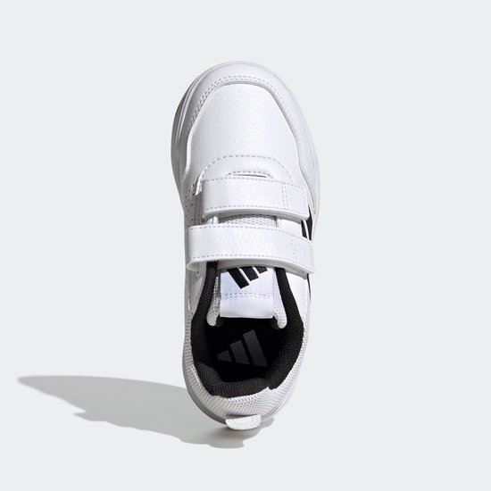 Witte kindersneaker met klittenbandsluiting, zwarte Adidas-strepen en een witte zool.