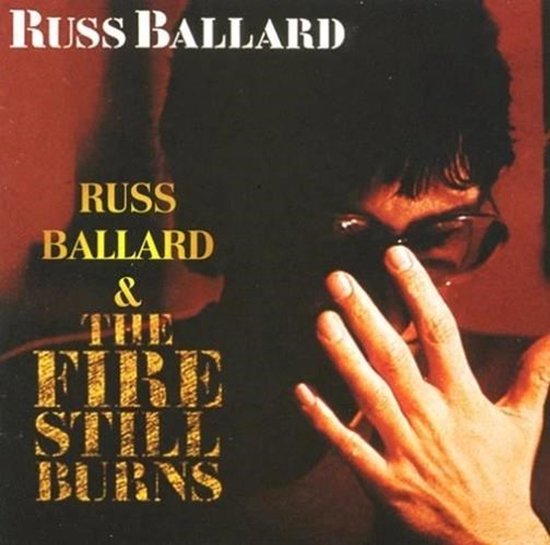 Russ Ballard met de tekst 'Russ Ballard & The Fire Still Burns'. Voorkant CD-hoes.