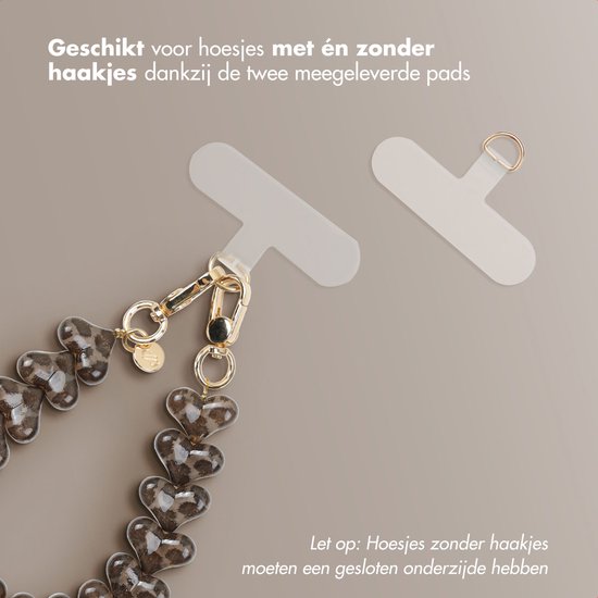 Twee doorzichtige telefoonbandjes met een goudkleurige lus, een telefoonkoord met bruine hartjes met luipaardprint.