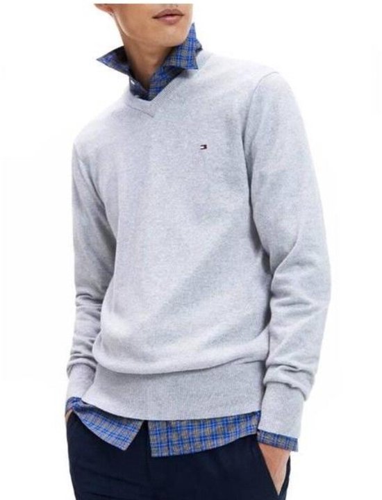 Model draagt lichtgrijs katoenen V-hals vest met Tommy Hilfiger logo boven geruit overhemd.