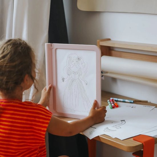 Kind met oranje gestreepte kleding houdt roze lichttablet met getekende prinses.