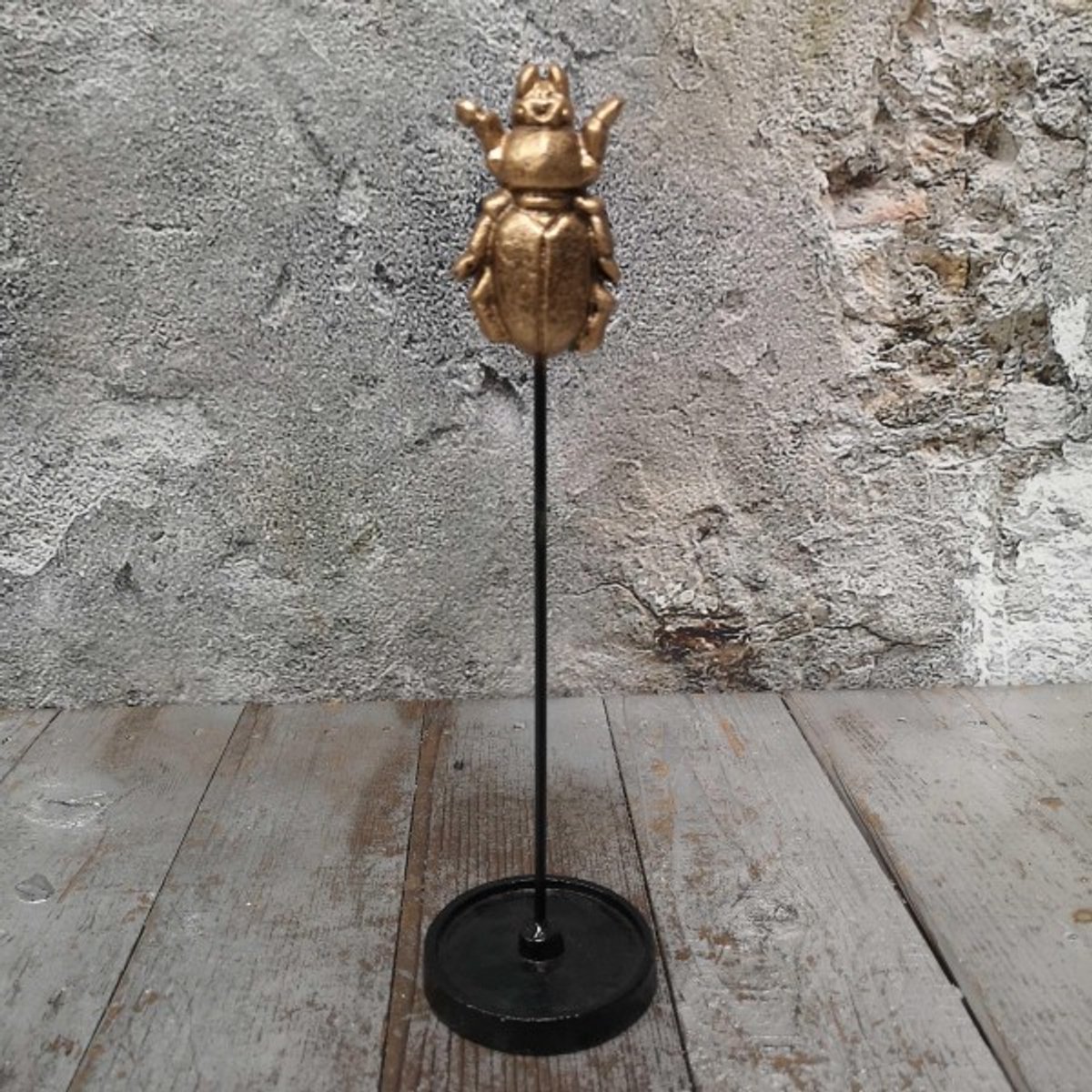 Gouden insect op standaard