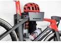 Zwarte en rode racefiets met rode helm en bidon op een Stasdock muurbeugel.