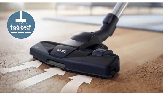 Aspirateur violet Philips sur un tapis, avec tuyau et manche, dans un salon.