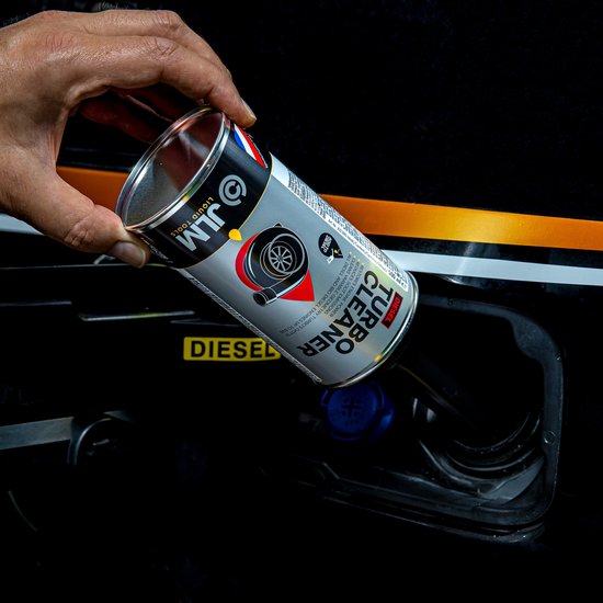 Hand giet JLM Diesel Turbo Cleaner uit zilveren fles in een dieseltank.