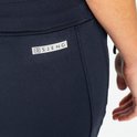 Close-up van het label 'SJENG' op de achterkant van een donkerblauwe sportbroek.