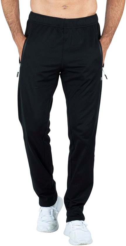Man in zwarte trainingsbroek met ritszakken, witte sneakers.