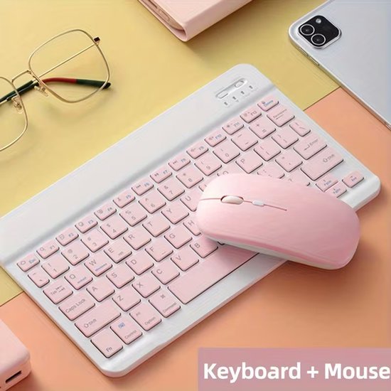 Roze Bluetooth toetsenbord met roze muis, naast een bril en een telefoon.