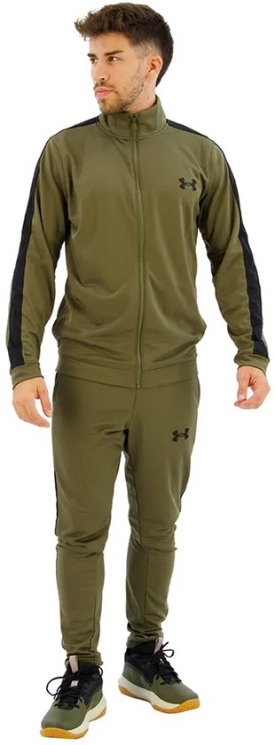 Man met groen Under Armour trainingspak met zwarte accenten en logo's. Op de mouwen en zijkanten van de broek.