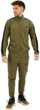 Man met groen Under Armour trainingspak met zwarte accenten en logo's. Op de mouwen en zijkanten van de broek.