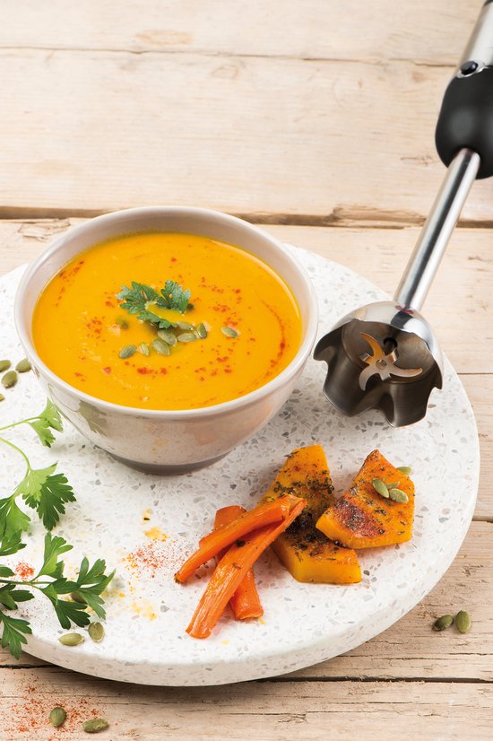 Fritel staafmixer in oranje pompoensoep met geroosterde wortels en pompoen.