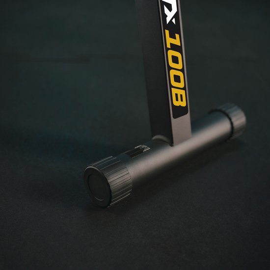 Detail van de zwarte trainingsbank met gele "TX 100B" opdruk.