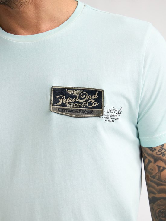 Lichtgroen T-shirt met op de borst een label met "Petrol Ind. Motorworks & Co. Custom Repair".