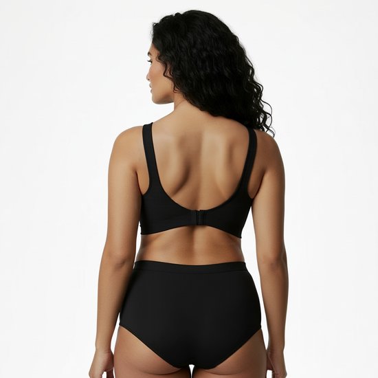 Zwarte beha en bijpassende slip, gezien vanaf de achterkant. Model met donker, golvend haar.