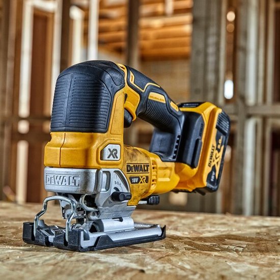 De gele DeWalt 18V XR decoupeerzaag staat op een houten ondergrond.