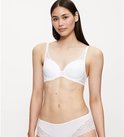 Model draagt een witte beha en slip met kanten details.