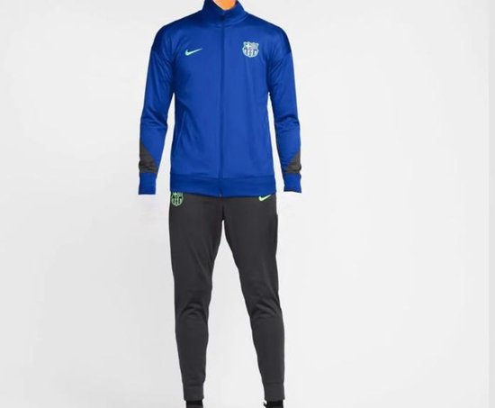 Koningsblauw trainingspak met antracietgrijze broek. Het jack heeft een groen Nike logo en FC Barcelona embleem.