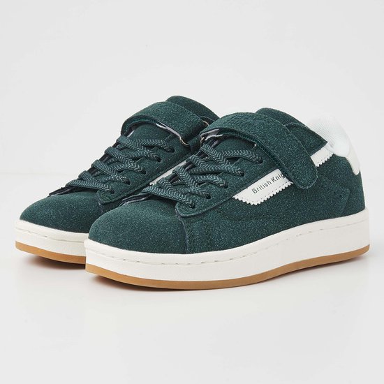 Paire de baskets vert foncé en suède avec fermeture velcro, accents blancs et semelles blanches.
