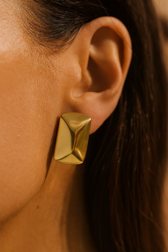 Clou d'oreille géométrique doré porté à l'oreille, Lundholm.