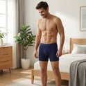 Man met gespierd bovenlichaam in een donkerblauwe boxershort.