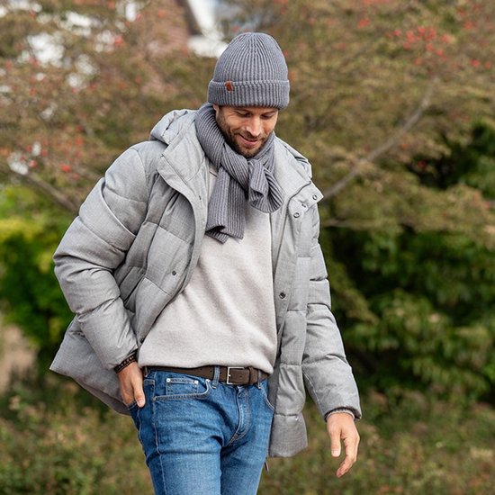 Homme portant une veste grise chinée, une écharpe, un bonnet, un pull gris clair et un jean bleu. Ceinture en daim marron avec boucle argentée.