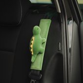 Groene gordelbeschermer met een zachte dinosaurus-applicatie op een autogordel.