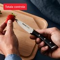 Hand houdt aardbei vast naast Tefal schilmes