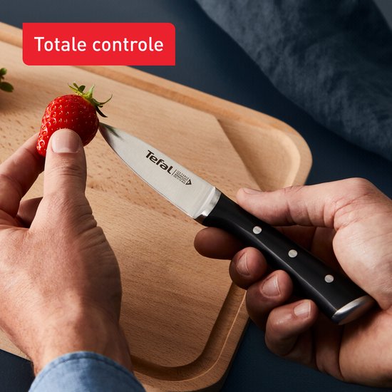 Hand houdt aardbei vast naast Tefal schilmes