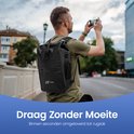 Man met zwarte NAYD rugzak op zijn rug, neemt een foto met zijn telefoon. Rugzak kan ook als fietstas worden gedragen.