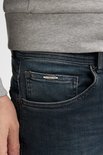 Close-up van de voorkant van een donkerblauwe jeans met Petrol Industries logo.