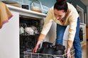 Vrouw plaatst de zwarte multicooker in een vaatwasser.