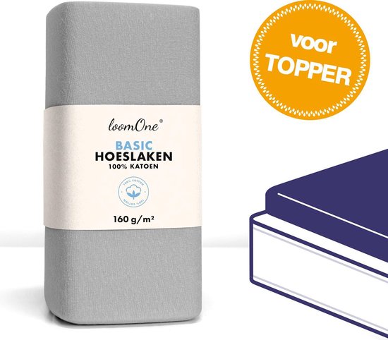 Drap-housse pour topper gris plié avec étiquette 'loom One BASIC HOESLAKEN 100% KATOEN 160 g/m²'. Cercle orange avec 'voor TOPPER'.