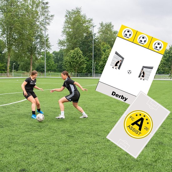 Twee meisjes spelen voetbal op groen veld, met kaarten met 'Derby' en 'FC ASSIST'.
