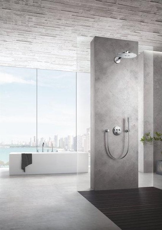 Moderne badkamer met grote ramen, betonlook wanden, vrijstaand bad en inbouw douche met handdouche.