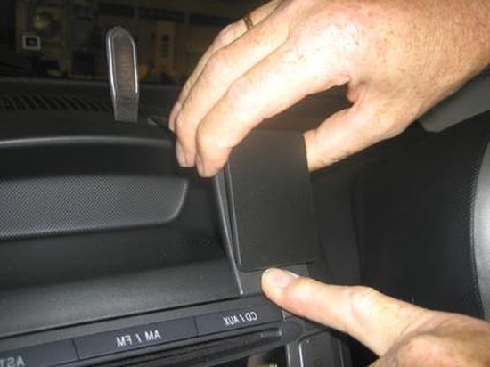 Gebruiker plaatst de Brodit ProClip montagebeugel in het dashboard, rechts van de radio.
