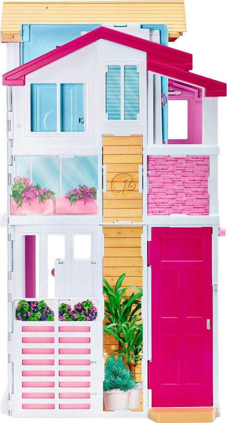 Roze en witte Barbie Malibu huis met 3 verdiepingen. De voorgevel heeft een roze deur, houten accenten en bloembakken.