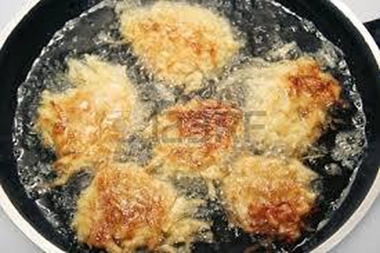Gefrituurde aardappelkoekjes in een pan met hete olie.