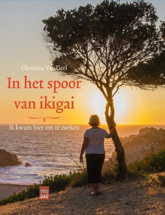 Boek 'In het spoor van ikigai' met op de cover een vrouw onder een boom bij zonsondergang aan zee.