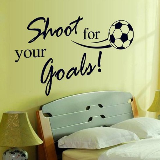 Muursticker met de tekst "Shoot for your goals!" en een voetbal, boven een bed.