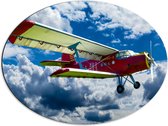 WallClassics - Dibond Ovaal - Rood/Geel Vliegtuig in Wolkenvelden - 68x51 cm Foto op Ovaal (Met Ophangsysteem)