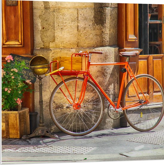 WallClassics - PVC Schuimplaat- Oranje Fiets bij Stenen Gebouw - 80x80 cm Foto op PVC Schuimplaat