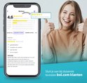 Jeune femme souriante pouces levés à côté d'un téléphone affichant des avis positifs et une note élevée.