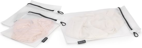 Drie witte gaaswaszakjes, met daarin roze en beige kledingstukken.