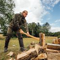 Man met Muck Boot Wetland Pro laarzen in het bos, hakkelend hout.