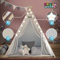 Witte tipi speeltent 's nachts met sterverlichting en details van de kussens en het materiaal.