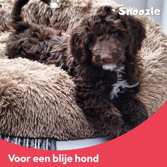 Bruine puppy in een ronde, pluizige, crèmekleurige hondenmand met het merk "Snoozle" in de rechterbovenhoek.