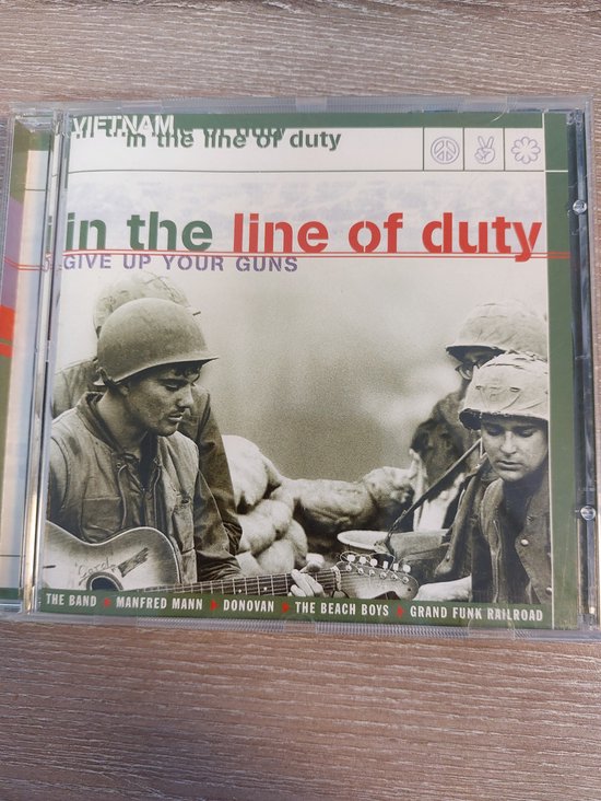 CD-hoes met twee soldaten in gevechtstenue, met de tekst 'in the line of duty'.