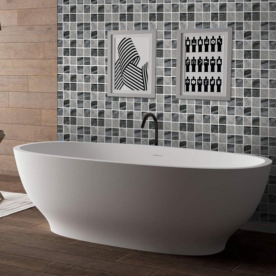 Salle de bain avec baignoire îlot et mur de carreaux de mosaïque en marbre gris.